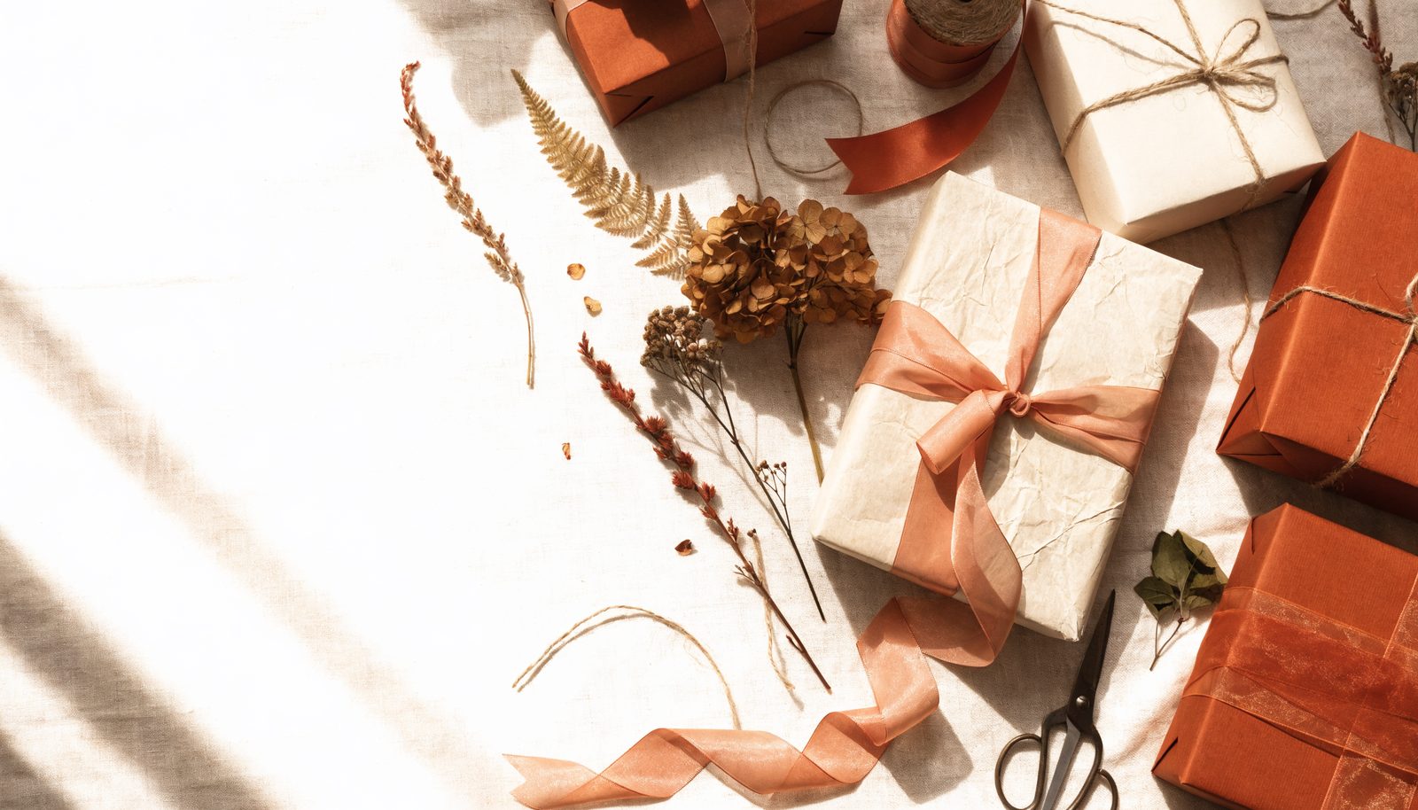 Liebevoll verpackte Geschenke in Creme und Terracotta